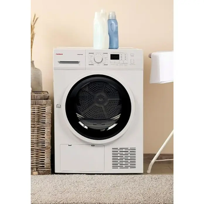 Corberó Secadora CSBCM105 - L x An x Al: 66 x 59,5 x 84,5 cm, Carga soportada: 10 kg - Vista frontal de una secadora blanca marca Carberg con líquidos de limpieza encima, que está sobre una alfombra.