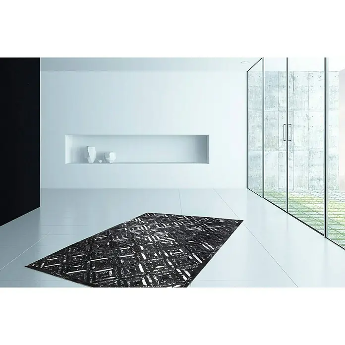 Kayoom Lederteppich DazzleSchwarz/Silber, 150 x 80 cm, 100 % Leder - Bild eines schwarzen Teppichs mit abstraktem Muster in einem modernen, minimalistischen Raum, der Stil und Komfort vereint.