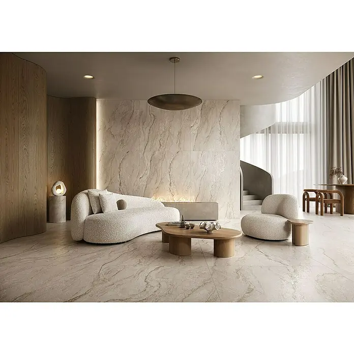 Feinsteinzeugfliese Velluto - 59,8 x 119,8 cm, Beige, Matt - Elegantes Wohnzimmer mit Marmorwänden und Boden. Die weiche Couch und der Sessel laden zum Verweilen ein. Die Einrichtung ist modern und stilvoll.