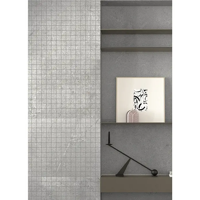 RAK Ceramics Valdi Mosaikfliese - 30 x 30 cm, Light Grey, Matt - Graue Fliesenwand mit minimalistischen Regalen, die dekorative Kunstwerke und Skulpturen präsentieren, die ein modernes Raumgefühl schaffen.