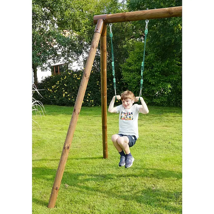 Soulet Turnring-Set - Grün - Ein Junge schwingt auf einer Holzschaukel im Garten, die grüne Seile hat. Die Schaukel steht auf einem grünen Rasen unter Bäumen.