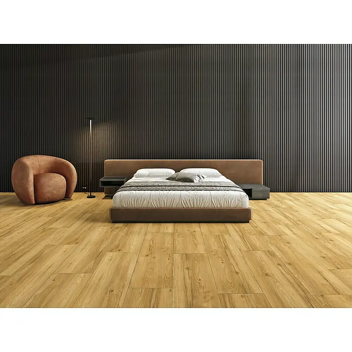 LOGOCLIC Laminat Twenty Five XXL - Oak, Landhausdiele, 1.288 x 330 x 9 mm - Elegantes Schlafzimmer mit einem einladenden Bett, einem modernen Sessel und stilvoller Beleuchtung für eine entspannte Atmosphäre.
