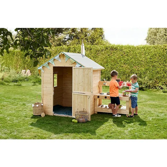 Soulet Spielhaus Jasmine - L x B x H: 221 x 127 x 162 cm - Kinder spielen in einem hellen Holzspielhaus mit integrierter Spielküche im Garten, umgeben von üppigem Grün.
