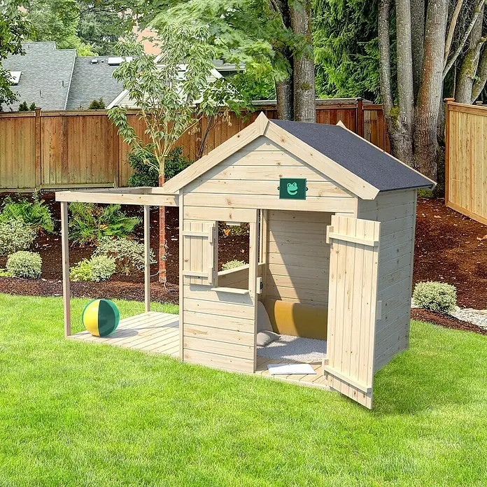 Soulet Spielhaus Epicerie - L x B x H: 245 x 128 x 165 cm, Holz - Ein hölzernes Spielhaus mit schwarzem Dach und grüner Froschdekoration im Garten. Eine Tür ist offen und ein Ball liegt auf der Veranda.