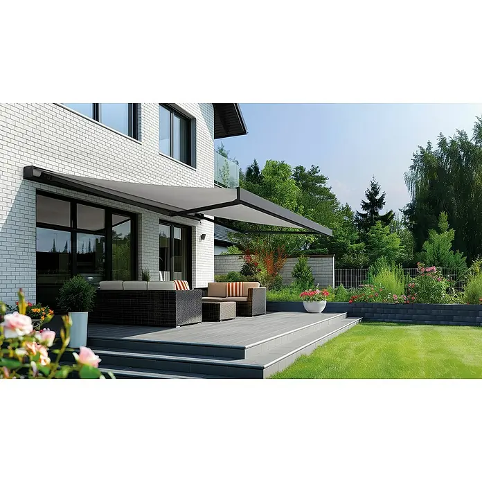 Spettmann Vollkassettenmarkise 1927 - Grau, Farbe Gestell: Eisenglimmer matt, Breite: 6 m, Ausfall: 3 m - Eine stilvolle, ausfahrbare Markise spendet Schatten auf einer Terrasse mit modernen Gartenmöbeln und üppigem Grün.