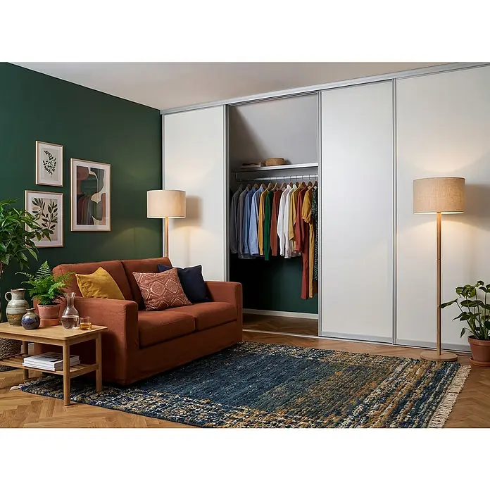 Room Plaza Easy Doing Schiebetür-Bau-Set - Reinweiß Miniperl, Farbe Beschlag: Silber - Wohnzimmer mit großem Kleiderschrank mit Schiebetüren, Sofa, Beistelltisch, Stehlampen und blauem Teppich.
