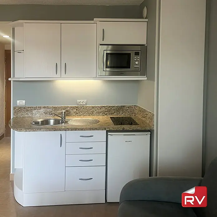 Lámina decorativa autoadhesiva vinílico autoadhesivo a metros - Madera sólida blanca - Cocina americana compacta con fregadero, fogones, microondas y nevera blanca. Ideal para espacios pequeños.