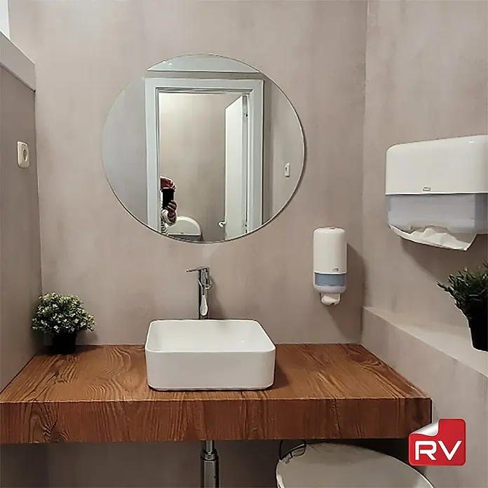 Lámina decorativa autoadhesiva vinílico autoadhesivo a metros - Piedra clara - Un lavabo de cerámica blanca con encimera de madera, complementado con un espejo redondo y un dispensador de jabón, ofrece una solución elegante y funcional.