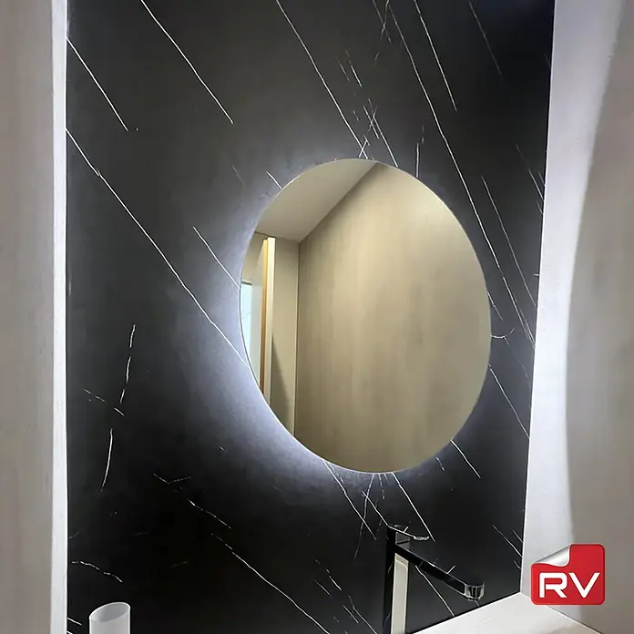Lámina decorativa autoadhesiva vinílico autoadhesivo a metros - Mármol calacatta negro - Lavabo de baño moderno con un elegante espejo redondo sobre un fondo de mármol negro para un aspecto elegante.