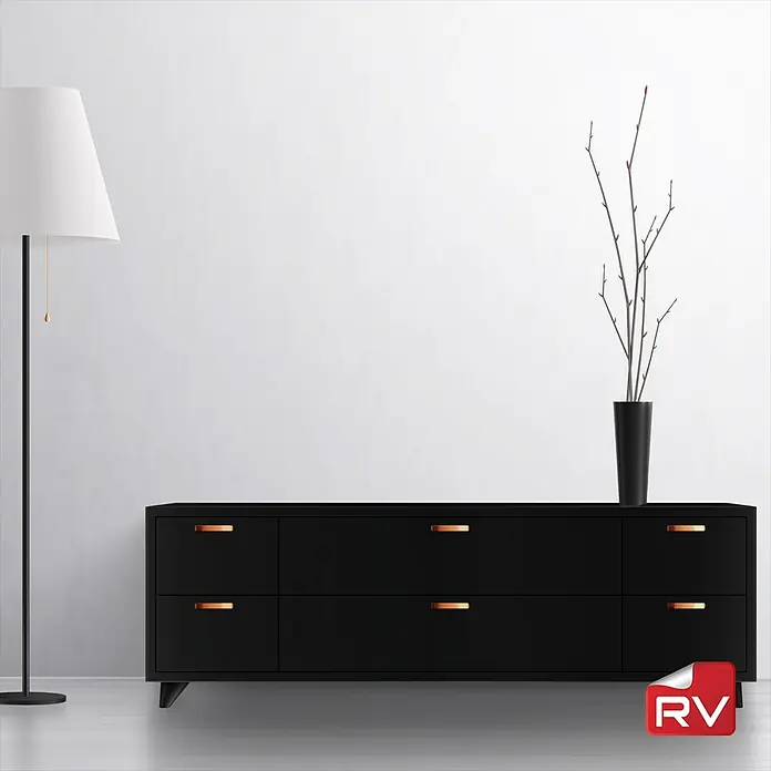 Lámina decorativa autoadhesiva vinílico autoadhesivo a metros - Madera sólida negra - Elegante aparador negro con un diseño minimalista y tiradores de cobre, complementado con una lámpara de pie moderna y ramas decorativas en un jarrón.