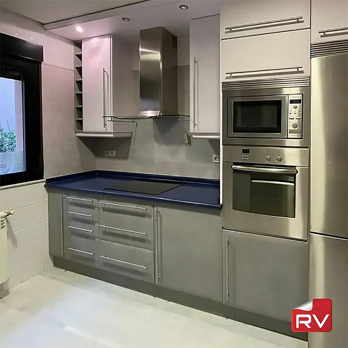 Lámina decorativa autoadhesiva vinílico autoadhesivo a metros - Hormigón gris - Cocina luminosa con encimera azul, campana extractora de acero inoxidable, horno y microondas. Los armarios de cocina son modernos y funcionales.