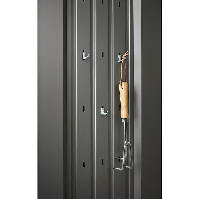 Biohort Romeo Gerätehaus - Außenmaß inkl. Dachüberstand (B x T): 132 x 87 cm, Stahl, Quarzgrau-Metallic - Das Bild zeigt eine graue, metallene Werkzeugwand mit Haken und einem aufgehängten Gartenwerkzeug, das Platz für Ordnung und Übersicht schafft.