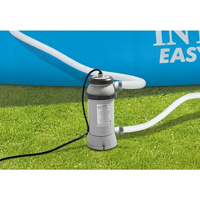Intex Poolheizung - Passend für: Pools bis 457cm Durchmesser, 3.000 W - Nahaufnahme einer Intex-Filterpumpe für Pools mit Schläuchen und Stromkabel auf grünem Gras vor einem blauen Pool.