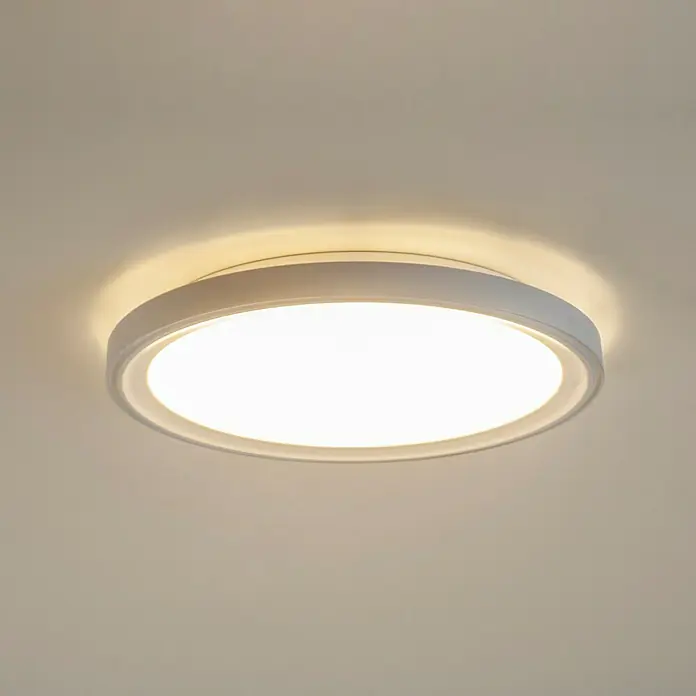 Brumberg LED-Deckenstrahler rund Anbaudownlight - Ø x H: 33 x 4,5 cm, Weiß matt, Warmweiß - Nahaufnahme einer runden, weißen LED-Deckenleuchte, die helles Licht abgibt und eine moderne und elegante Beleuchtungslösung darstellt.