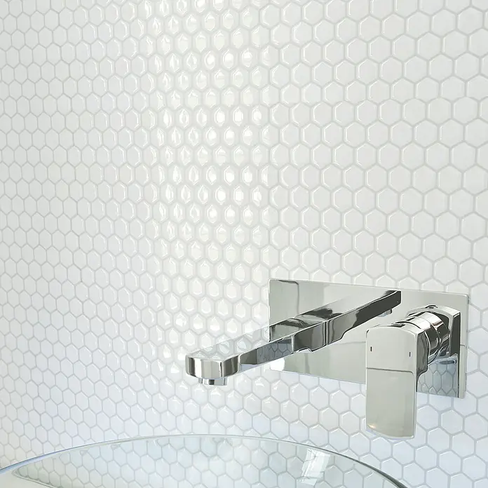 Smart Tiles Selbstklebemosaik Hexago - 24,46 x 28,6 cm, Weiss, Glänzend - Elegante Wandarmatur aus Chrom vor einer Wand mit weißen Sechseckfliesen, die jedem Badezimmer einen Hauch von modernem Luxus verleiht.