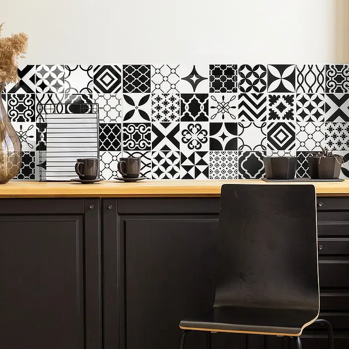 Smart Tiles Selbstklebemosaik Vintage - 22,86 x 22,86 cm, Bilbao, Glänzend - Blick auf eine Küche mit einer Arbeitsplatte, schwarzen Schränken und einer Rückwand mit dekorativen Fliesen.
