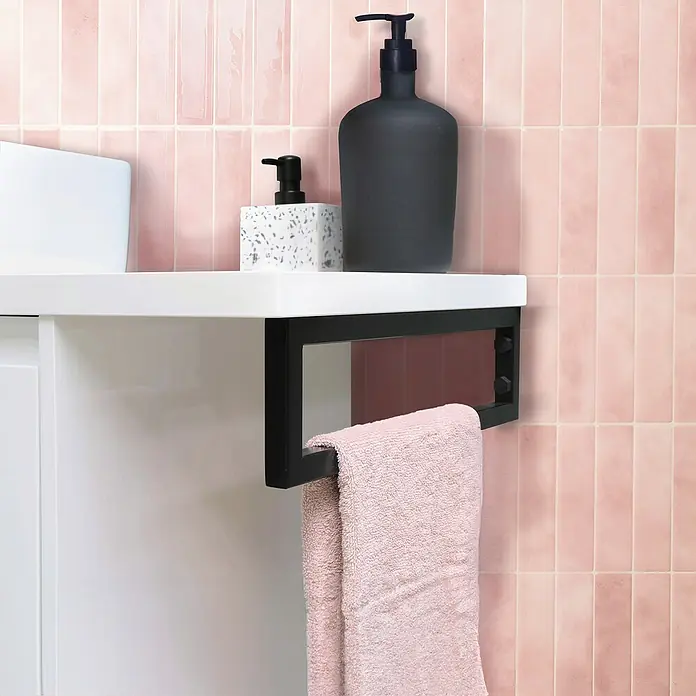 Smart Tiles Selbstklebemosaik Morocco - 29,02 x 22,86 cm, Rabat, Glänzend - Nahaufnahme eines Handtuchhalters mit rosafarbenem Handtuch vor rosa gefliestem Hintergrund, mit Seifenspendern auf einem Regal.