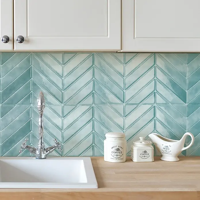 Smart Tiles Selbstklebemosaik Chevron - 29,02 x 22,86 cm, Taby, Glänzend - Detailaufnahme einer Küche mit türkisfarbenen Ziegeln, einem Spülbecken und dekorativen Aufbewahrungsbehältern, die die Ästhetik des Küchendesigns hervorheben.