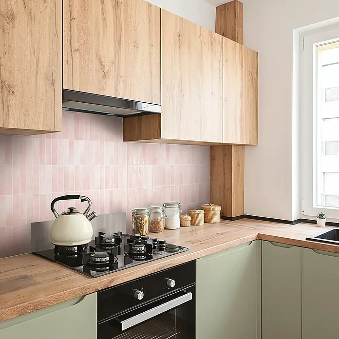 Smart Tiles Selbstklebemosaik Morocco - 29,02 x 22,86 cm, Rabat, Glänzend - Modernes Küchendesign mit hellgrünen Schränken und einer Kochinsel mit Herd und Backofen unter hölzernen Hängeschränken.