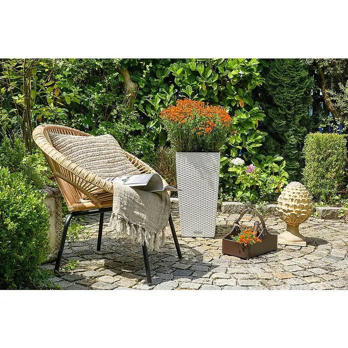 Lechuza Cottage Pflanzsäule eckig Cubico 40 - Außenmaß (L x B x H): 39,5 x 39,5 x 75,5 cm, Kunststoff, Weiß - Eine entspannende Gartenszene mit einem Korbsessel, einer gestrickten Decke und einem Pflanzgefäß, umgeben von üppigem Grün für eine ruhige Atmosphäre.