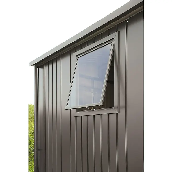 Biohort Kippfenster - Quarzgrau-Metallic - Nahaufnahme eines Kippfensters in einem modernen, metallverkleideten Gebäude, das geöffnet ist und einen Blick nach draußen ermöglicht.