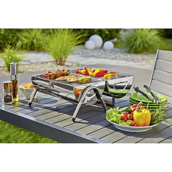 Grillstar Holzkohlegrill Dallas - Grillfläche (B x T): 34 x 22 cm, Silber - Bild eines Grills mit leckerem Essen auf einem Tisch im Freien, perfekt für ein Picknick oder eine Gartenparty.