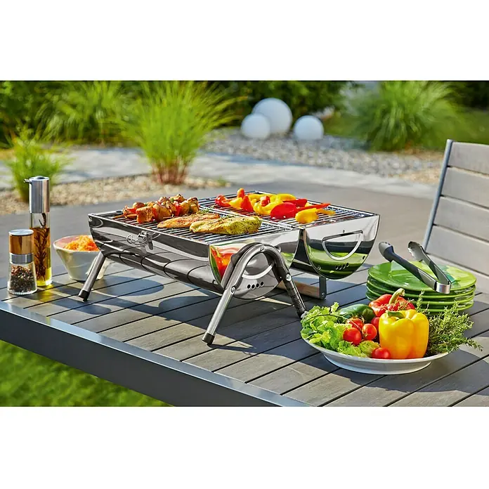 Grillstar Holzkohlegrill DallasGrillfläche (B x T): 34 x 22 cm, Silber - Bild eines Grills mit leckerem Essen auf einem Tisch im Freien, perfekt für ein Picknick oder eine Gartenparty.