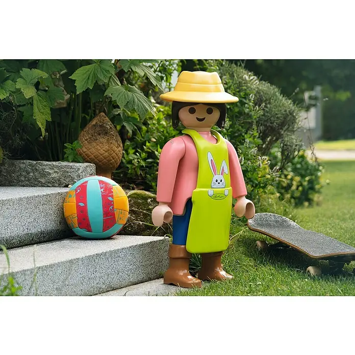 Lechuza Dekofigur Playmobil - Gärtnerin/Hase, L x B x H: 33 x 27 x 68 cm, Kunststoff - Playmobil-Figur mit gelbem Hut, rosa Hemd und grüner Schürze steht neben einem Ball und einem Skateboard im Garten.
