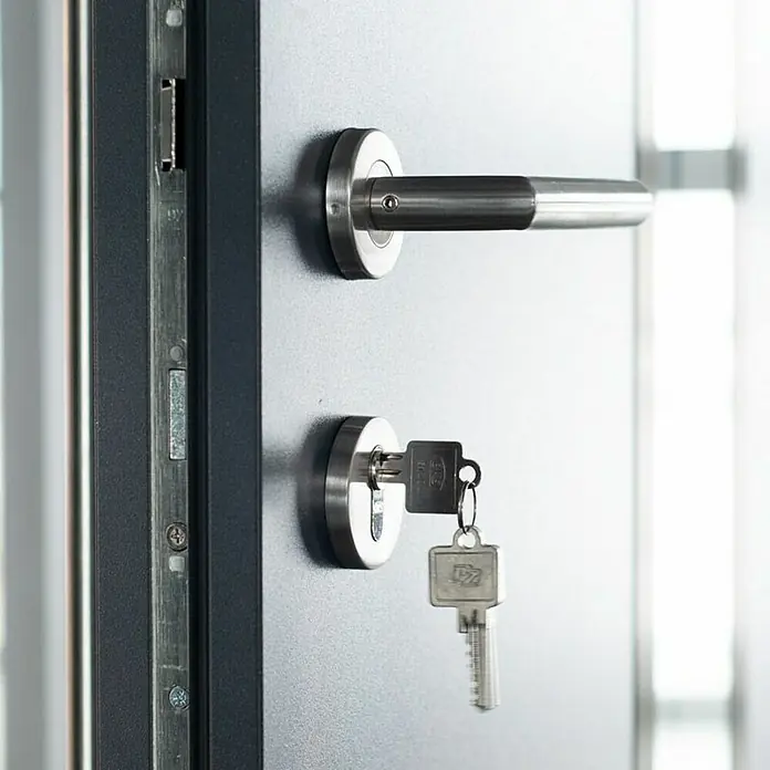 FM Türen Haustür AC68-520 RC 2 - 100 x 200 cm, DIN Anschlag: Rechts, Anthrazit - Nahaufnahme einer modernen Tür mit Griff und Schlüssel, die Sicherheit und Funktionalität vereinen.