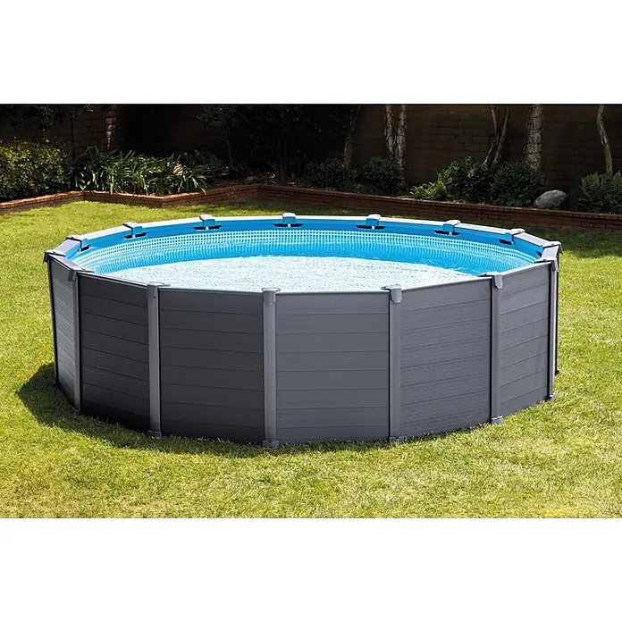Intex Frame-Pool Graphite - Ø x H: 478 x 124 cm, Anthrazit, 16.805 l - Aufstellpool mit grauem Holzrahmen und blauem Innenleben, eingebettet in einen grünen Garten.