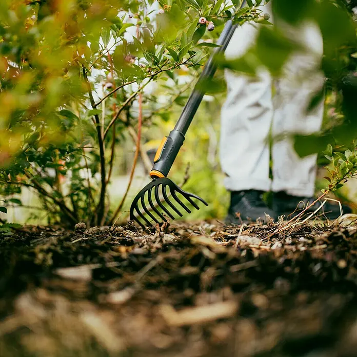 Fiskars OneClick Gartenrechen - Arbeitsbreite: 25 cm, Anzahl Zinken: 10 Stk. - Der Fiskars Laubfächer Rechen im Einsatz, perfekt für die Gartenpflege und die Beseitigung von Laub und Gartenabfällen.