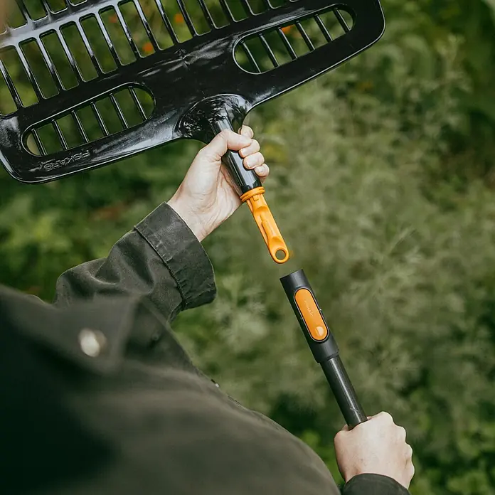 Fiskars OneClick Gartenrechen - Arbeitsbreite: 48,2 cm - Abgebildet ist ein Fiskars Rechen mit modularem System, bei dem der Kopf vom Stiel getrennt ist. Ideal für Gartenarbeiten.