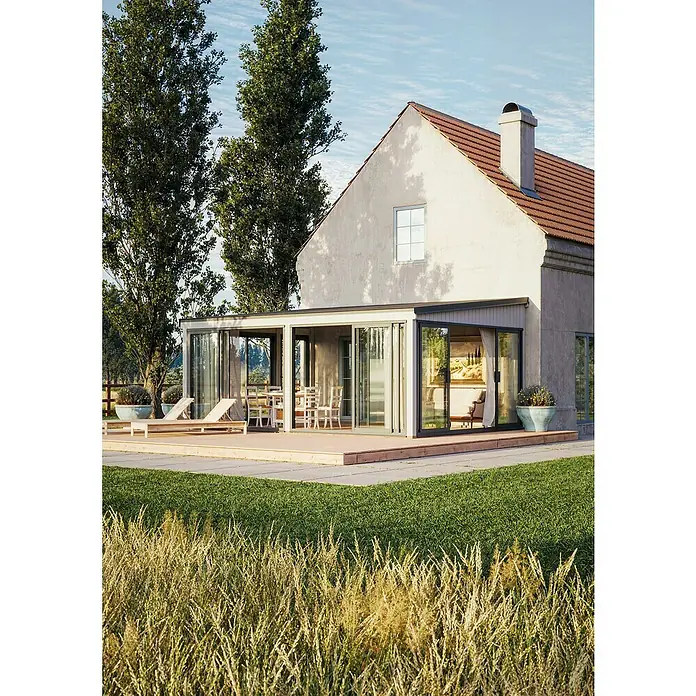 Palmako Pérgola adosada Lumi Slide Plus - L x An: 420 x 582 cm, Natural, Doble acristalamiento de 24 mm, Puerta corredera - Exterior de una casa con patio y extensión de vidrio. La casa presenta una arquitectura moderna y un diseño cercano a la naturaleza.