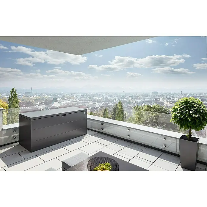 Biohort StyleBox Kissenbox 210 - L x B x H: 207 x 80 x 81 cm, Stahl, Dunkelgrau-Metallic - Eine graue Aufbewahrungsbox steht auf einem Balkon mit Blick auf die Stadt, perfekt für die Lagerung im Freien und als stilvolle Ergänzung.
