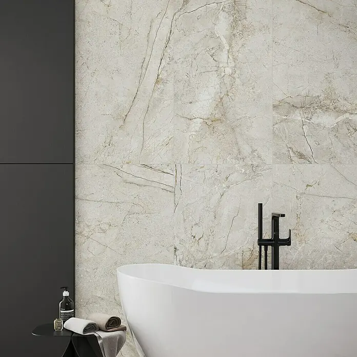 Feinsteinzeugfliese Sinkler - 59,8 x 119,8 cm, Light Grey, Matt - Elegantes Badezimmer mit Marmorfliesenwand, freistehender Badewanne und schwarzen Armaturen, die ein luxuriöses Ambiente schaffen.