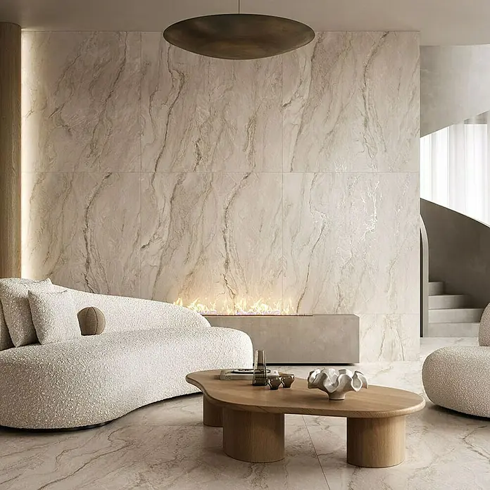 Feinsteinzeugfliese Velluto - 59,8 x 119,8 cm, Beige, Matt - Modernes Wohnzimmer mit Marmorwand, stilvollem Sofa und einem Couchtisch aus Holz. Die warme Beleuchtung sorgt für eine gemütliche Atmosphäre.