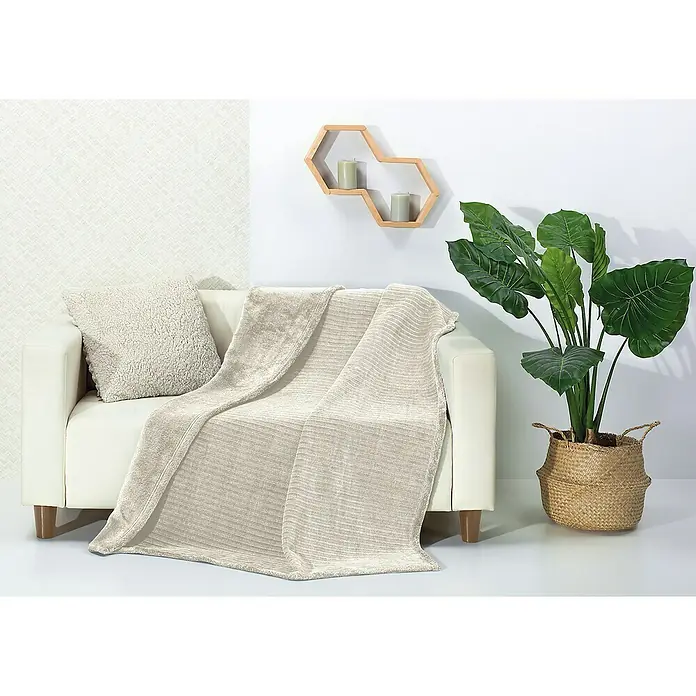 Manta para sofá Vesubio con borreguito - 160 x 220 cm, Poliéster, Crema - Un sofá beige con una manta suave y un cojín a juego, que crea un ambiente acogedor e invitante para relajarse.