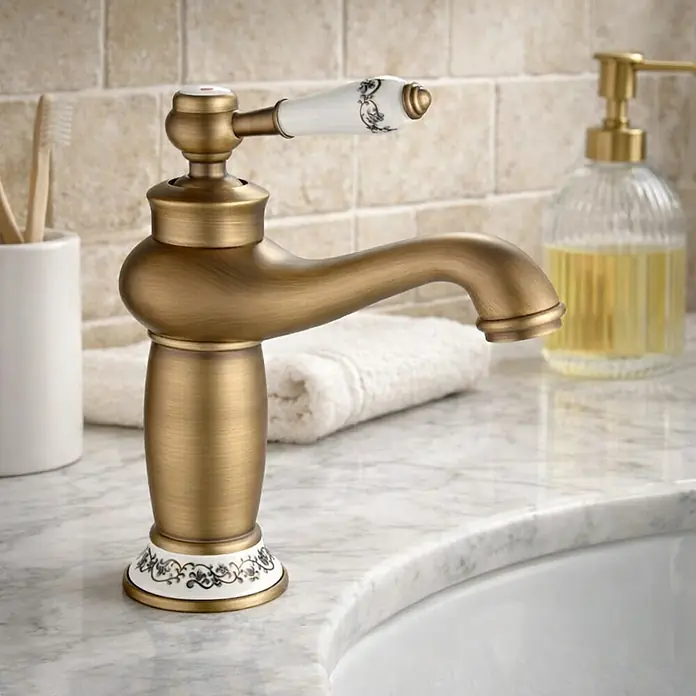 Rousseau Grifo de lavabo Marple - Bronce viejo, Satinado - Elegante grifo de baño en oro antiguo con un mango decorativo de porcelana y una base floral. Un atractivo para cualquier baño.