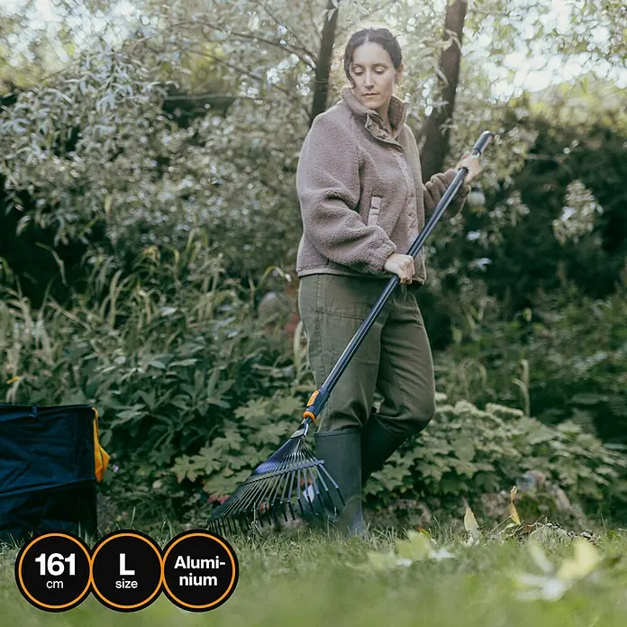 Fiskars OneClick Aluminiumstiel - Aluminium, 161,3 cm - Eine Frau harkt mit einem Aluminium-Laubbesen mit verstellbarer Länge Blätter im Garten.