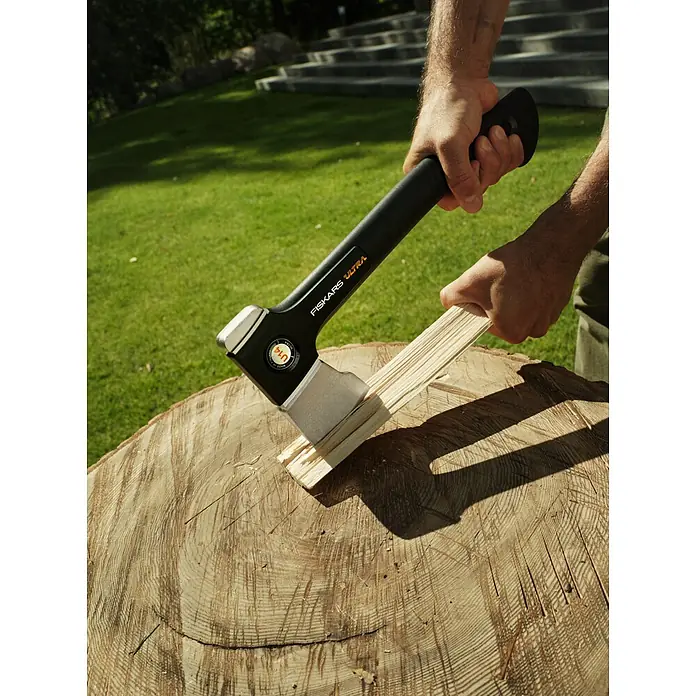 Fiskars Spaltaxt - Länge: 35,5 cm, 0,529 kg - Nahaufnahme einer Fiskars Ultra Spaltaxt, die in einem Holzstamm steckt. Die Axt hat einen schwarzen Griff und einen grauen Axtkopf.
