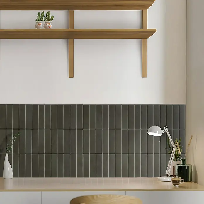Smart Tiles Selbstklebemosaik Morocco - 29,02 x 22,86 cm, Toulal, Matt - Nahaufnahme einer stilvollen Wand mit grauen, vertikalen Fliesen, einem Holzregal und dekorativen Elementen wie Pflanzen und einer Lampe.