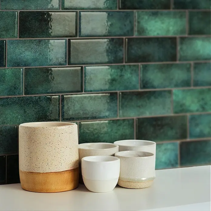 Smart Tiles Selbstklebemosaik Metro - 29,34 x 21,28 cm, Medina, Glänzend - Nahaufnahme von Keramikbechern vor einem Hintergrund aus grünen, rechteckigen Fliesen, ideal für Küchendekoration.