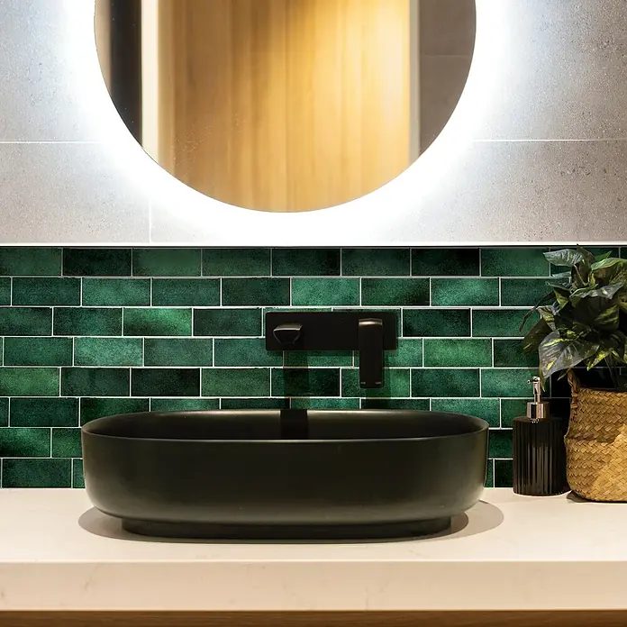 Smart Tiles Selbstklebemosaik Metro - 29,34 x 21,28 cm, Fiona, Glänzend - Nahaufnahme eines Badezimmers mit einer schwarzen Aufsatzwaschbecken und grünen Fliesen.