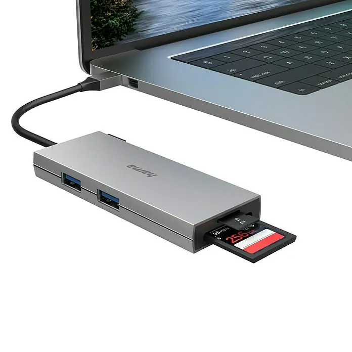 Hama USB-Hub 00200110 - USB A-Stecker, USB C-Stecker - Grauer Hama USB-Hub mit SD-Karte, verbunden mit einem Laptop. Praktisch für zusätzliche Anschlüsse und Datenspeicherung.