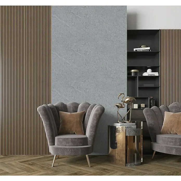 Panel de pared SPC Cast Grey - Gris, 1.250 x 600 mm - Elegante toma de dos sillones grises, mesa auxiliar dorada y elementos decorativos sobre un elegante panel de pared.