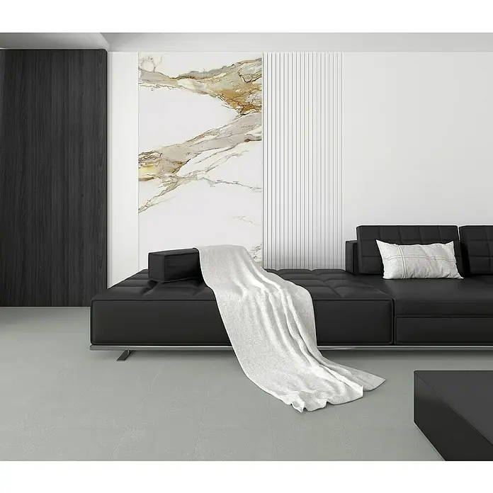 Panel de pared SPC Gold - Oro, 2.500 x 600 mm - Elegante sofá negro con una manta suave en un salón de diseño moderno.