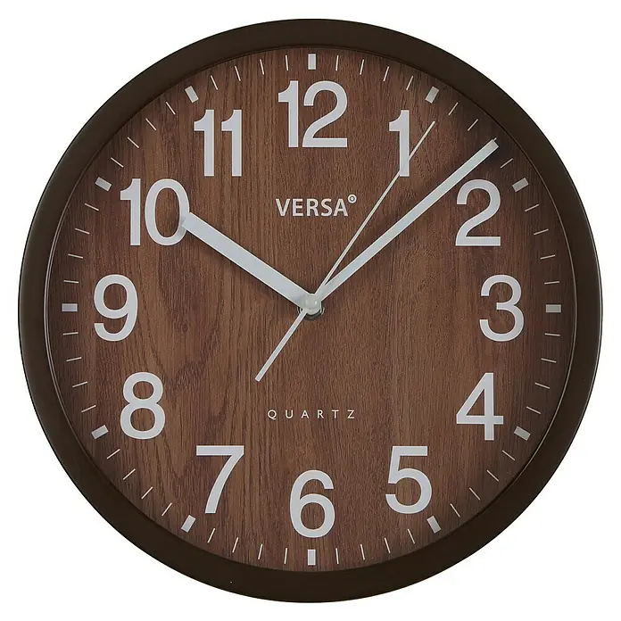 Versa Reloj de pared Madera oscura - Diámetro: 31 cm, Marrón, Clásico - Un reloj de pared marrón con números y manecillas blancas, que marca las 10:09. El reloj presenta un diseño de grano de madera en la esfera.