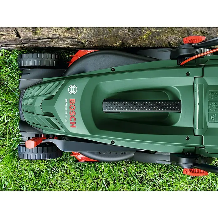 Bosch Universal Elektro-Rasenmäher UniversalRotak 37-570 - 1.400 W, Schnittbreite: 37 cm - Draufsicht auf einen grünen Bosch UniversalRotak 37 Rasenmäher, der auf Gras steht und von einem Holzstück begrenzt wird.