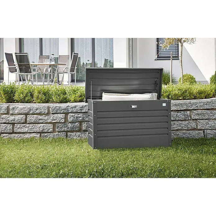 Biohort FreizeitBox Gartenbox 100 - L x B x H: 101 x 46 x 61 cm, Dunkelgrau Metallic, Stahl - Ein grauer Gartenbox mit geöffnetem Deckel steht auf dem Rasen. Die Box bietet Stauraum für Gartenutensilien und Sitzkissen.
