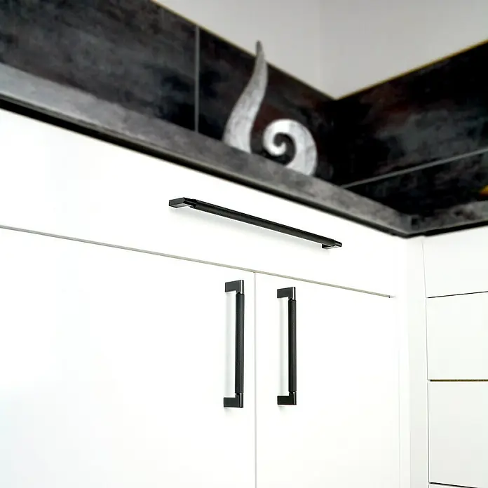 Siro Möbelgriff - Typ Möbelgriff: Bügel, Sonstige, Sonstige, Schwarz, Länge: 142 mm - Ein Küchenschrank mit modernen schwarzen Griffen, die das schlichte, weiße Design ergänzen. Die Griffe sind ein stilvolles Detail.